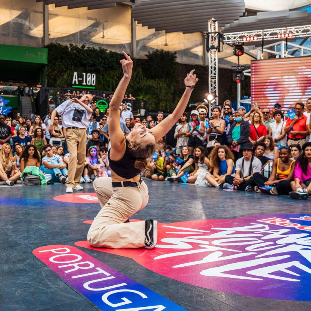Bailarina de breakdance actuando sobre el suelo del evento "Red Bull Dance Your Style Portugal", ante el público